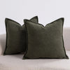 A set of three solid olive green textured boucle throw pillows resting on a light-colored sofa.