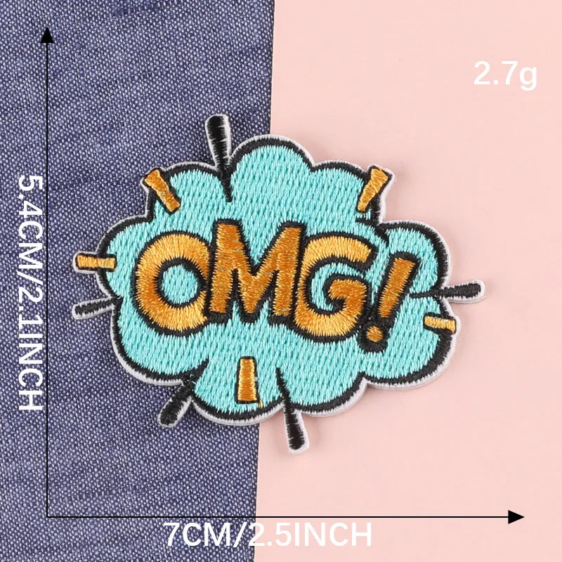 A teal embroidery patch shaped like a speech bubble with the text OMG in gold thread on a dark blue fabric background.