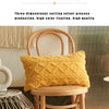 A textured yellow velvet cushion cover is displayed on a wooden chair in a modern interior setting.