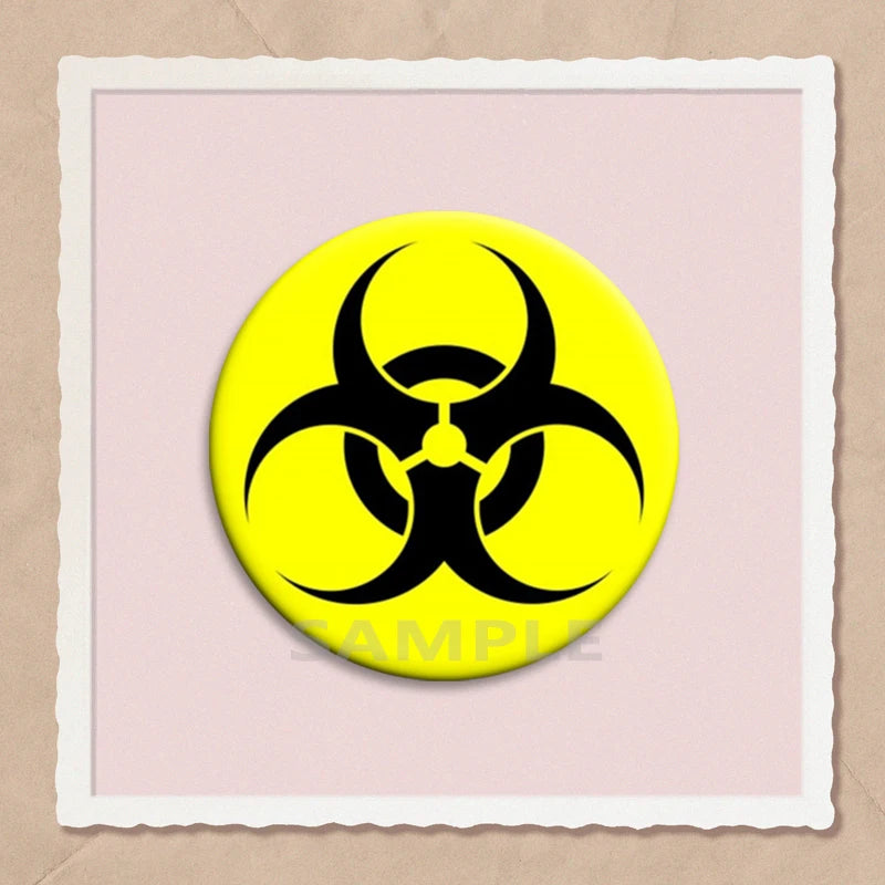 A yellow circular pin featuring a black biohazard symbol on a light pink background.