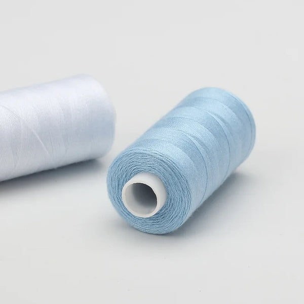 A roll of light blue sewing thread is shown next to a larger roll of the same thread.