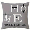 Gray pillow featuring the words HOME and SWEET HOME in white text with silhouettes of birds.