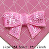 Pink sequin bow patches for DIY decoration shown on a pink cutting mat.