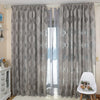 Gray sheer jacquard curtain panels hanging in a window with sheer inner layers