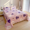 Pink flat bed sheets with purple and white heart patterns on a double bed