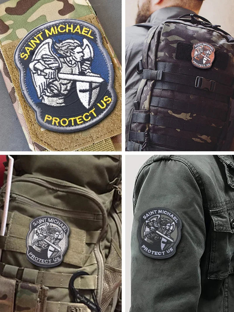 Close-up of St. Michael embroidered hook and loop tactical patches on camouflage fabric and a green jacket.