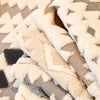 Close-up of a beige and gray patterned fleece fabric used for a sofa slipcover.