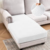 A white jacquard stretch sofa cushion cover placed on a beige sofa and resting on a rug.