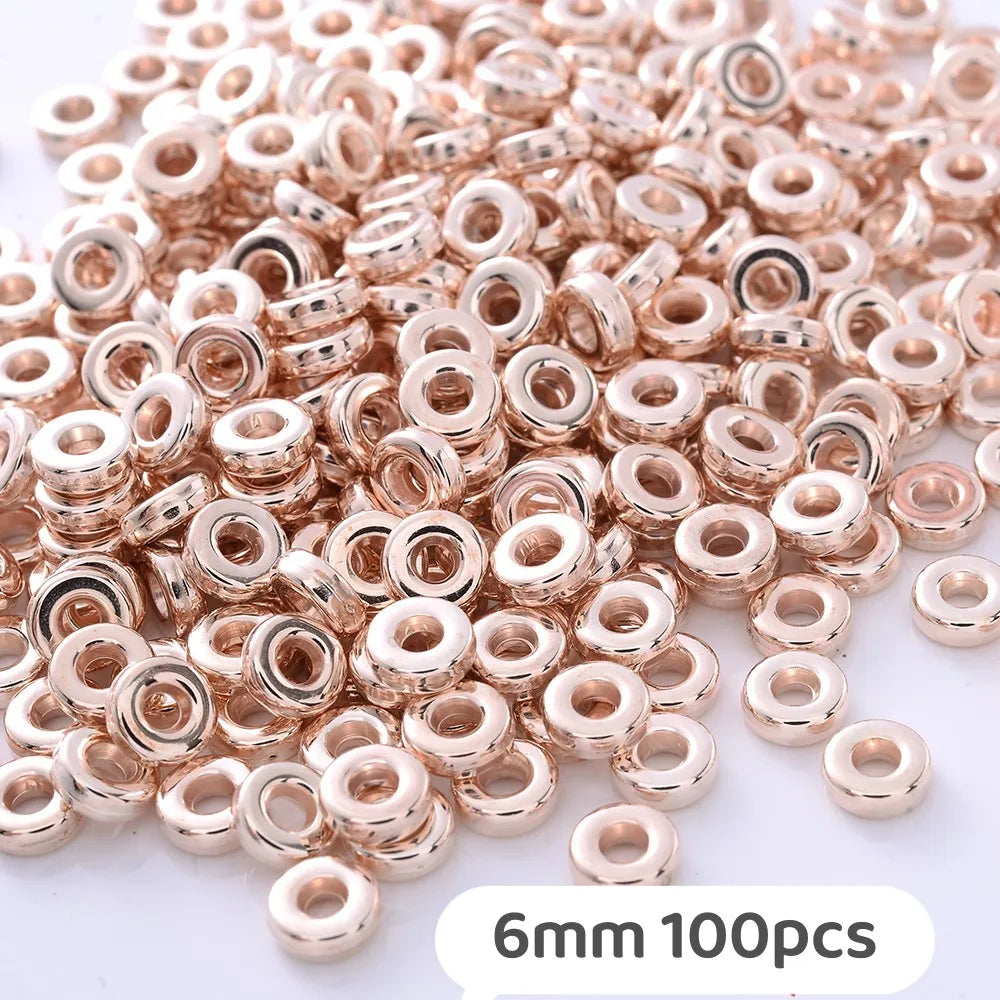 A pile of small rose gold and silver-toned geometric acrylic beads for jewelry making