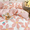 Pink floral bedding set featuring large peach and pink flower patterns on white fabric.