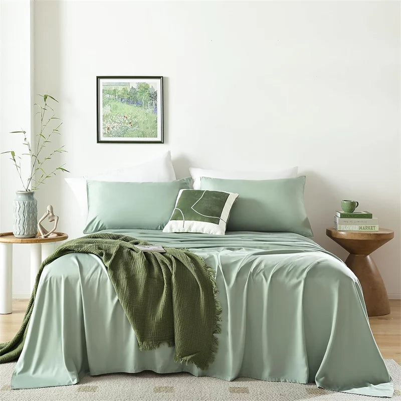 A luxury organic bamboo bed sheet set in sage green and olive green tones on a bed.