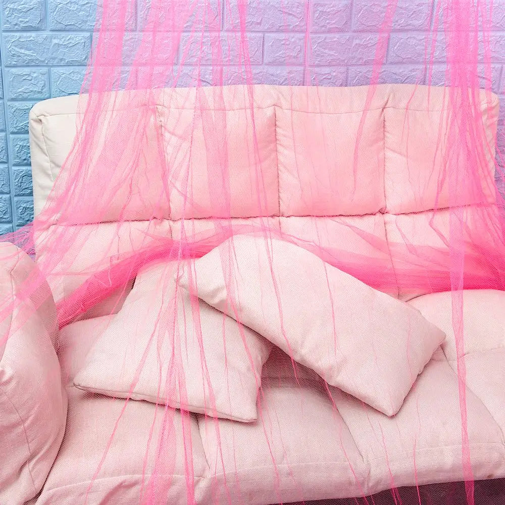 Pink lace dome mosquito net canopy draped over a bed or furniture