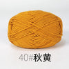 A ball of golden yellow organic cotton 4ply knitting yarn with an X-pattern weave.