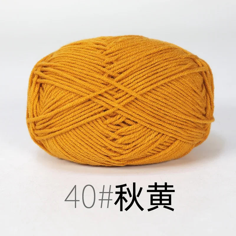 A ball of golden yellow organic cotton 4ply knitting yarn with an X-pattern weave.