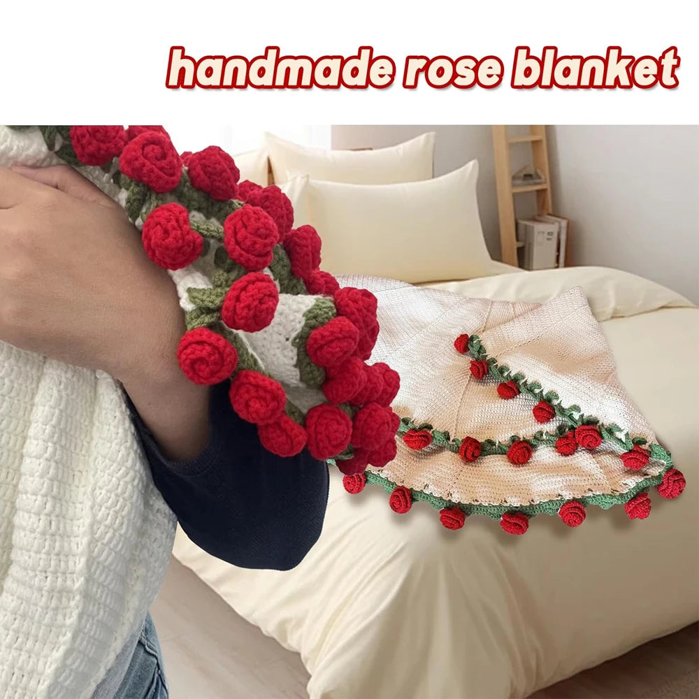 A close-up of a handmade rose crochet blanket featuring red floral accents, displayed on a white bed with pillows.