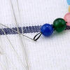 Precision stainless steel beading needles with colorful beads on a white background