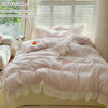 A pink and white lace duvet cover set displayed on a bed with matching pillowcases in a bright room.
