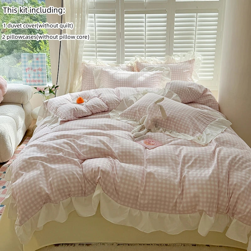 A pink and white lace duvet cover set displayed on a bed with matching pillowcases in a bright room.