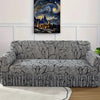 A gray pleated fabric sofa cover displayed against a white wall with an oil painting of a cityscape.