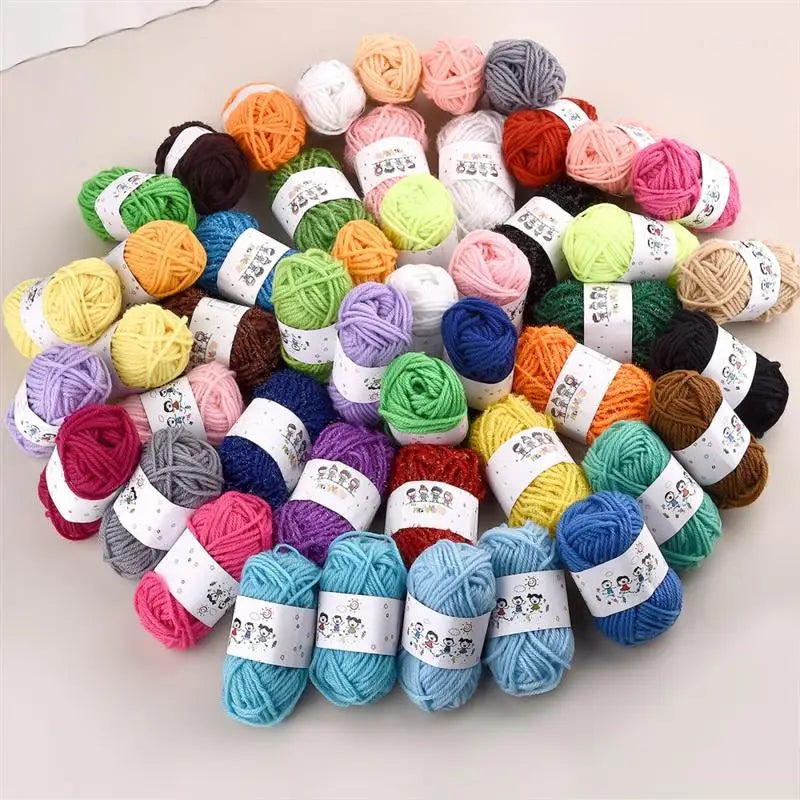A pile of 12-color soft acrylic yarn balls in various shades of pink, green, yellow, purple, and brown.