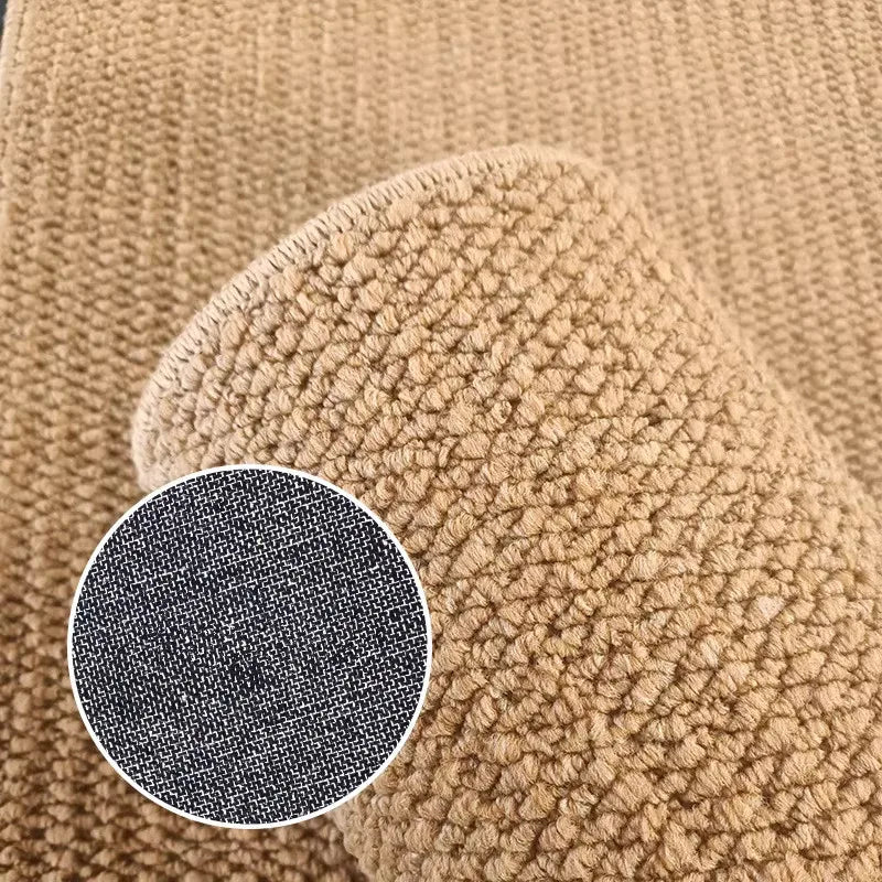 Close-up of a hand wearing a natural sisal jute rug with a dark gray circular detail.