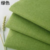 Green coarse linen and cotton fabric stacked and laid out for DIY projects