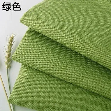 Green coarse linen and cotton fabric stacked and laid out for DIY projects
