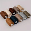 A collection of ten rolls of high-quality polyester sewing thread in various shades of brown, beige, and gray.