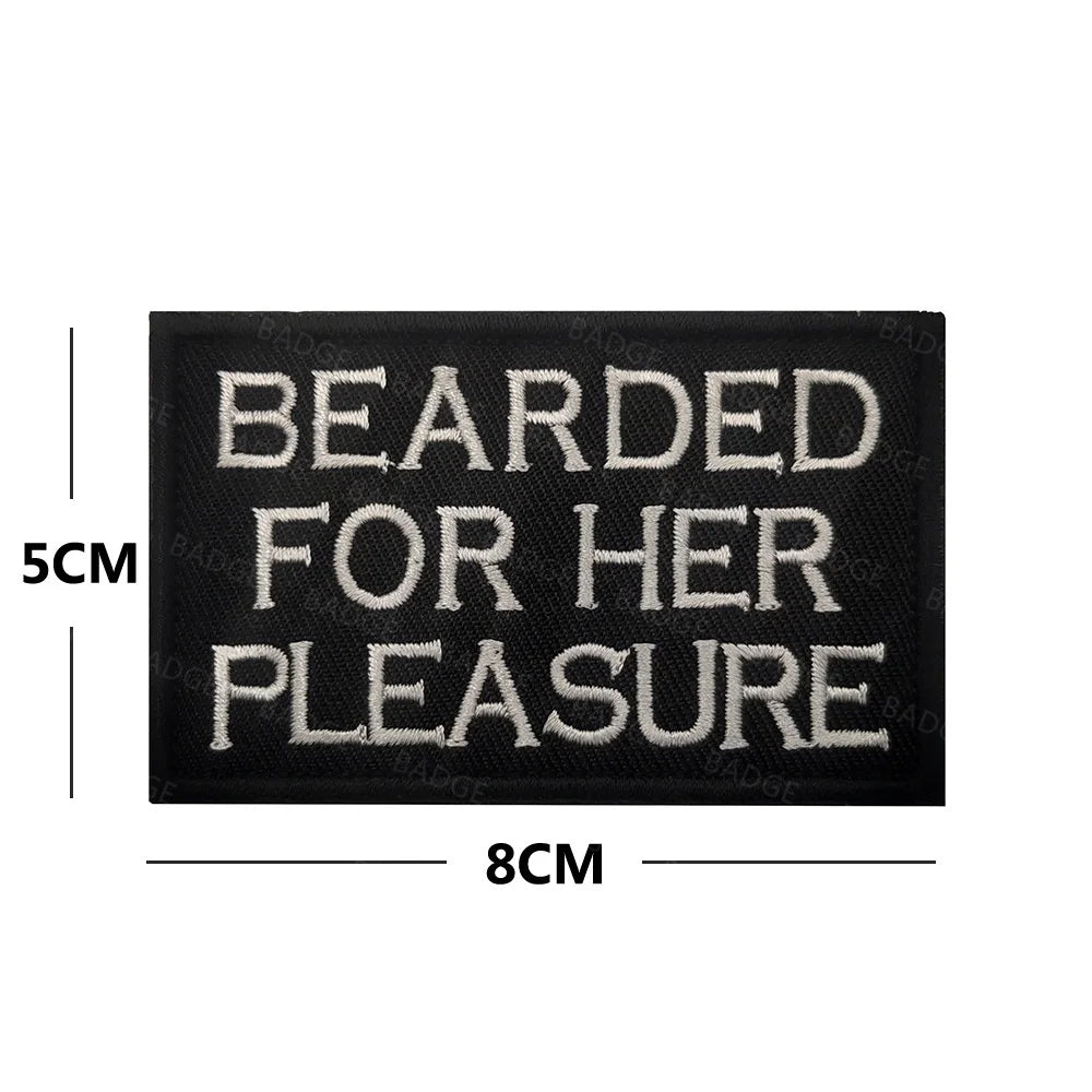 Black embroidered patch with white text reading Bearded for her pleasure and dimensions 5cm by 8cm