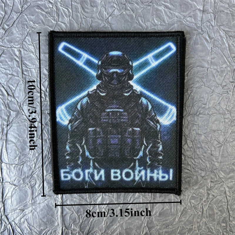 A black tactical skull patch hook and loop badge featuring a stylized helmet silhouette with glowing blue lines and the text 