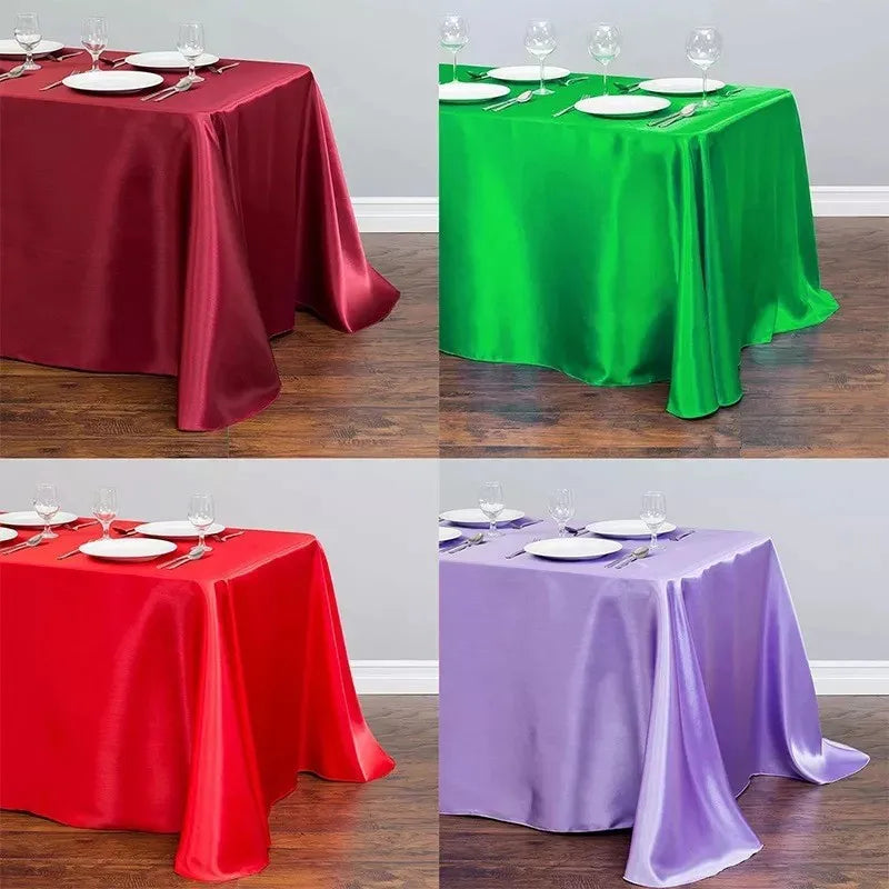 Three satin tablecloths in red, green, and purple displayed on a wooden floor.