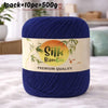 A skein of dark blue silk bamboo blend yarn labeled premium quality on a white background.
