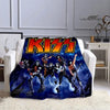 A dark blue printed flannel travel blanket featuring a graphic of KISS members in dynamic poses.