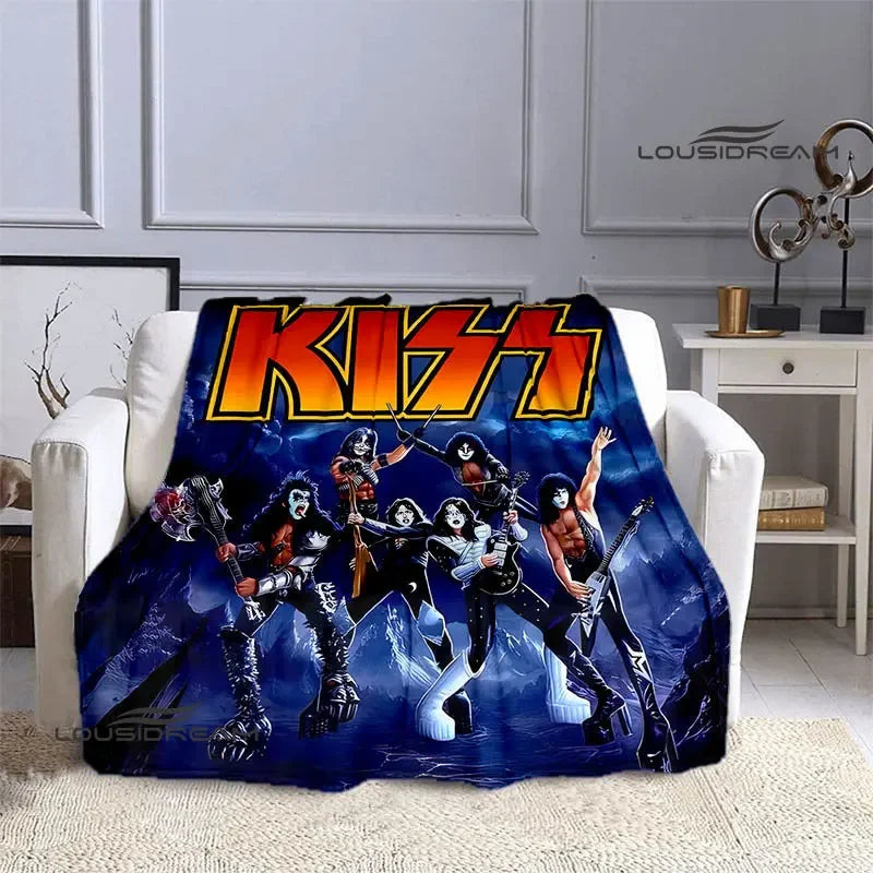 A dark blue printed flannel travel blanket featuring a graphic of KISS members in dynamic poses.