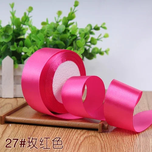 Roll of bright pink satin ribbon for gift wrapping and DIY crafts