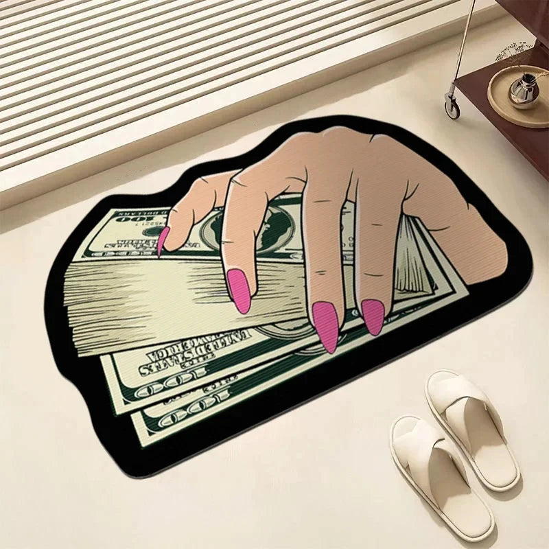 A hand is holding a stack of US dollar bills printed on an irregular black non-slip area rug.
