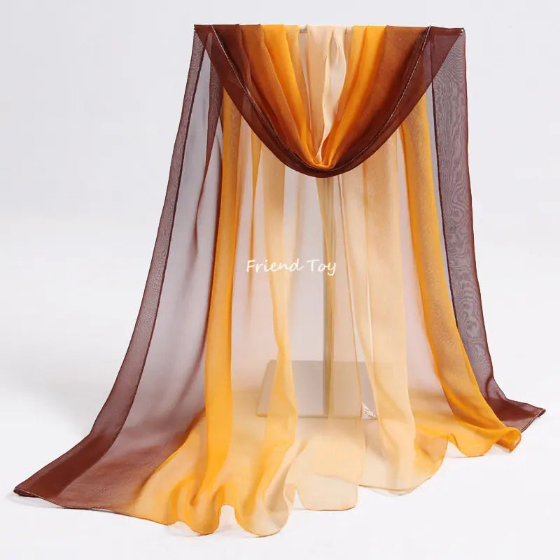 A display of flowing, sheer fabric scarves in shades of orange, yellow, and brown for sensory play.