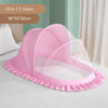 Pink foldable mosquito net canopy with a ruffled edge shown on a bed.
