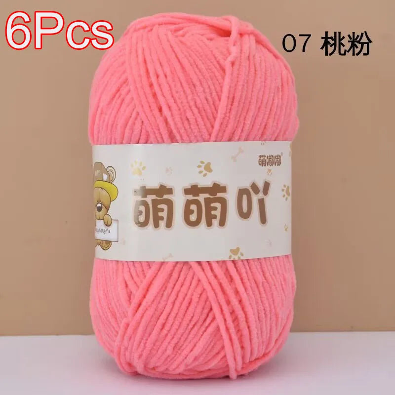 A skein of bright pink soft bulky chenille yarn labeled in Chinese characters and packaged for crafting