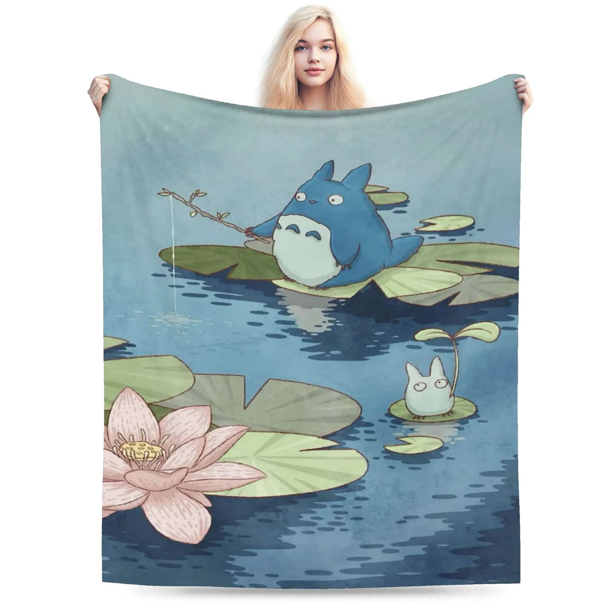 A soft fleece throw blanket featuring the Totoro character in a watercolor style on a teal background.