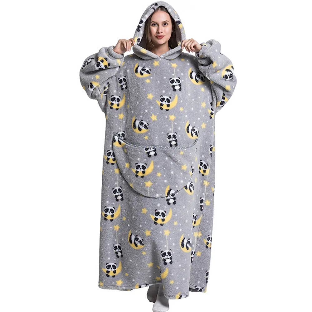 A woman models a gray sherpa fleece oversized blanket hoodie patterned with cute panda faces on a light background.
