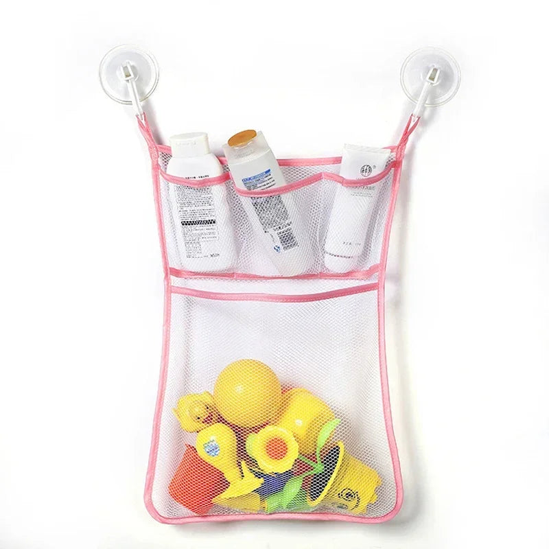 A pink mesh organizer bag holding various toddler bath toys including bottles and yellow plastic toys.