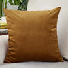 A square, deep olive velvet cushion cover resting on a light-colored sofa.