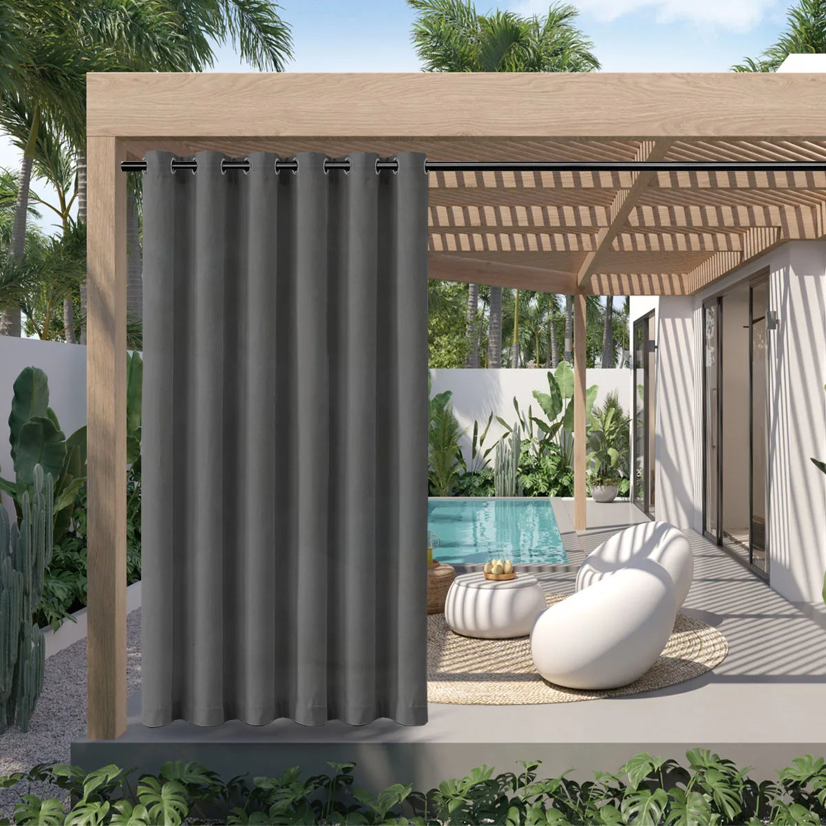 A gray waterproof outdoor curtain with a grommet top is installed on a wooden pergola structure in a modern patio setting.