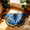 A blue and black irregular shaped plush floor rug is displayed on a wooden floor next to potted plants.