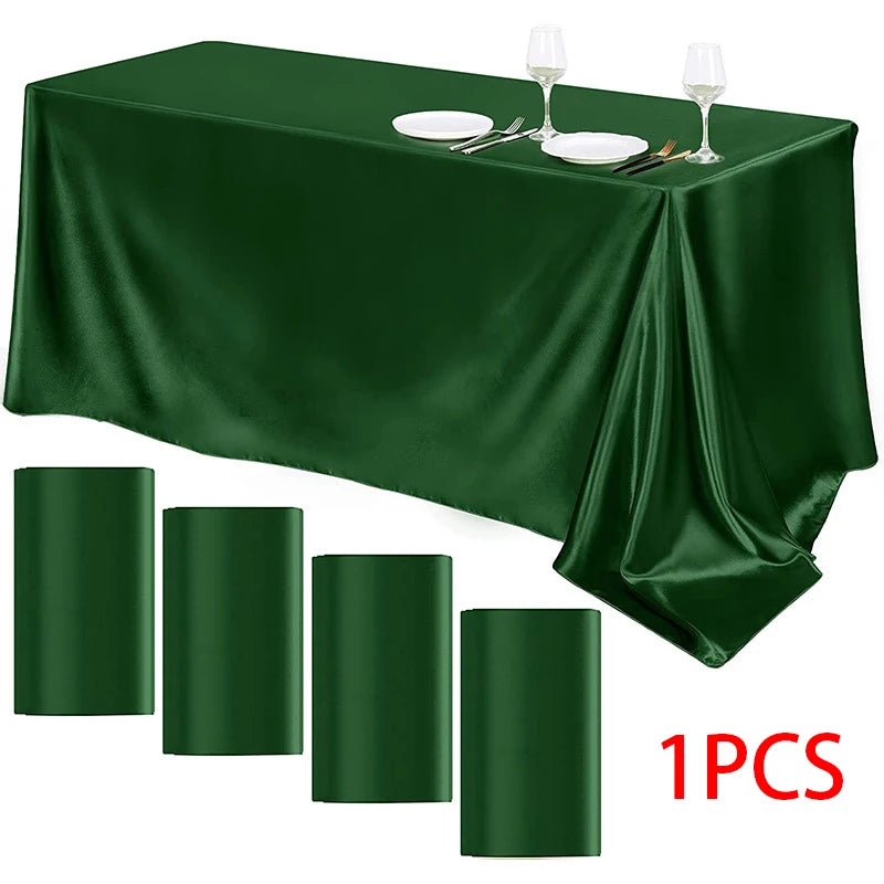 A dark emerald green satin rectangle tablecloth displayed with silverware and wine glasses.