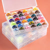 A clear plastic box containing a multicolor sewing bobbin set with various colored bobbins.