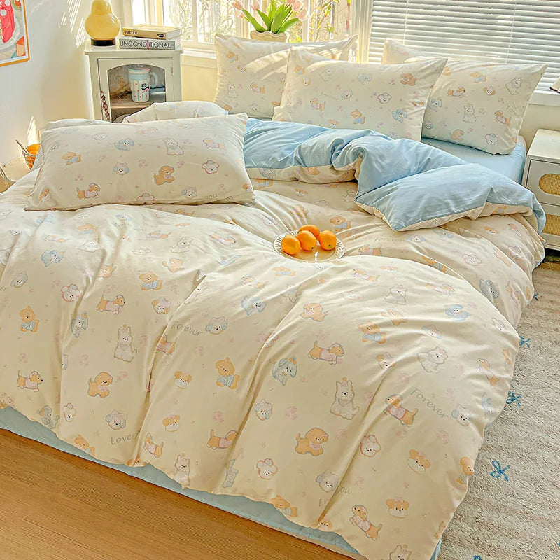 Light yellow floral printed bedding set with blue accents on a bed.