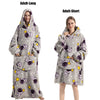 A gray plush fleece blanket hoodie with purple and yellow stars and astronaut designs shown on an adult model.