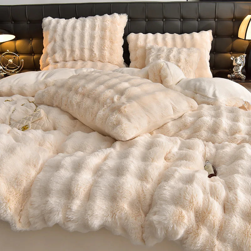 A plush rabbit hair bedding set featuring cream-colored pillows and a fluffy duvet on a dark background.